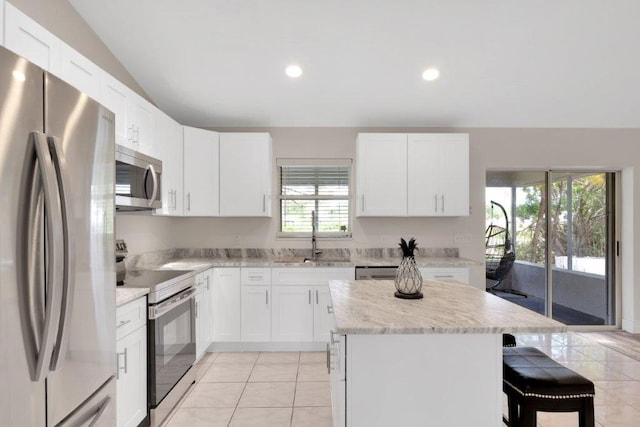 kitchen featuring stainless steel appliances, a kitchen island, sink, and white cabinets