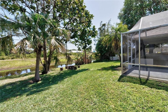 view of yard with a water view and a lanai