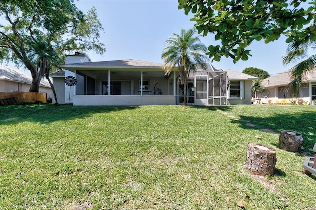 back of house featuring a yard and a lanai