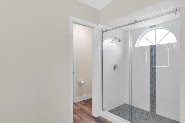 bathroom with hardwood / wood-style flooring and an enclosed shower