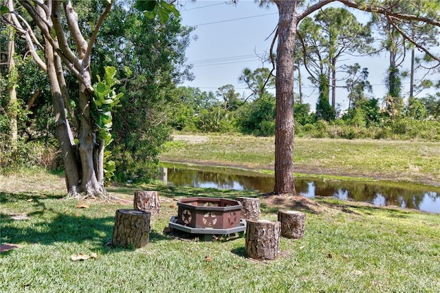 view of yard featuring a water view and a fire pit