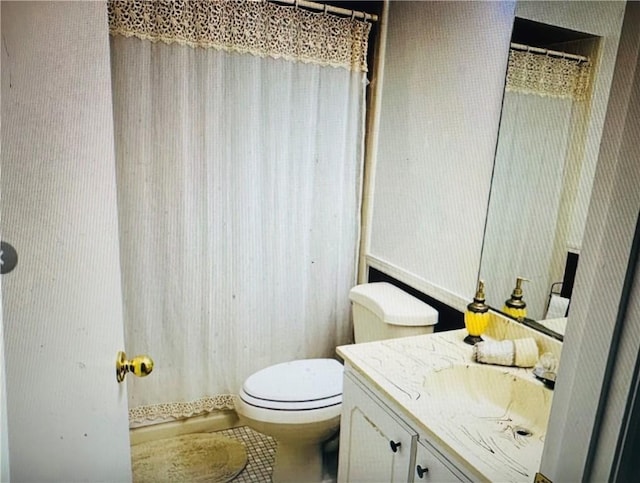 bathroom featuring tile patterned flooring, vanity, walk in shower, and toilet