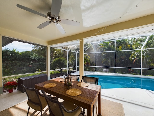 view of swimming pool featuring a patio, glass enclosure, and ceiling fan