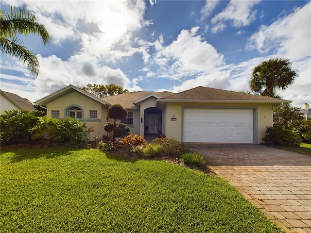 single story home with a garage and a front lawn