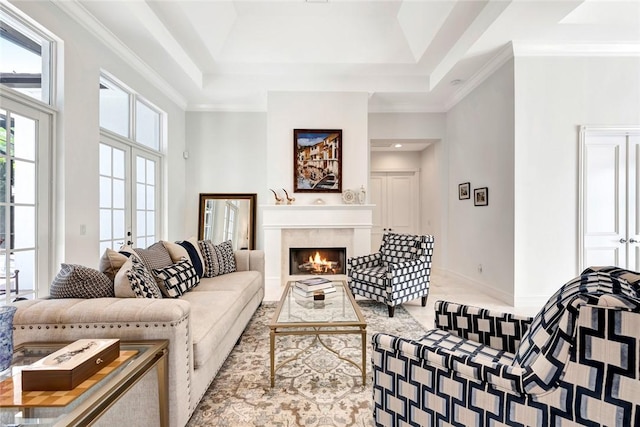 living room featuring crown molding, a towering ceiling, a premium fireplace, and french doors