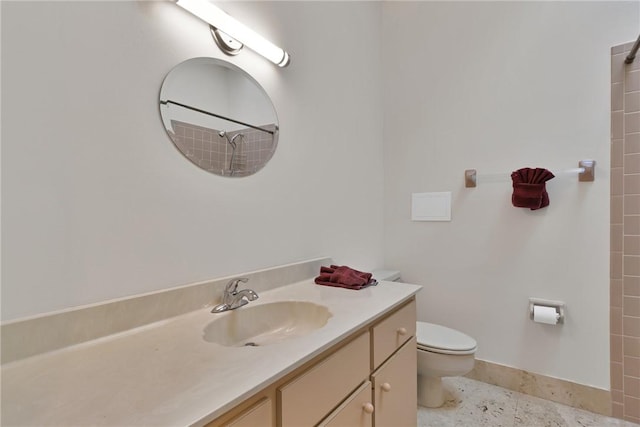 bathroom with vanity, toilet, and a shower