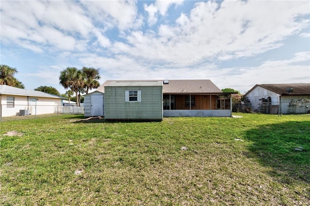 rear view of property with an outbuilding, a lawn, and a fenced backyard