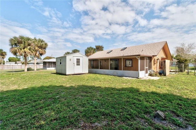 rear view of property featuring a storage unit, a lawn, an outdoor structure, and a sunroom