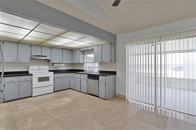 kitchen featuring stainless steel dishwasher, dark countertops, white electric range, and under cabinet range hood