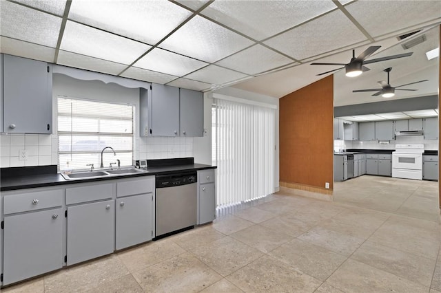 kitchen featuring dark countertops, under cabinet range hood, stainless steel dishwasher, white electric range oven, and a sink