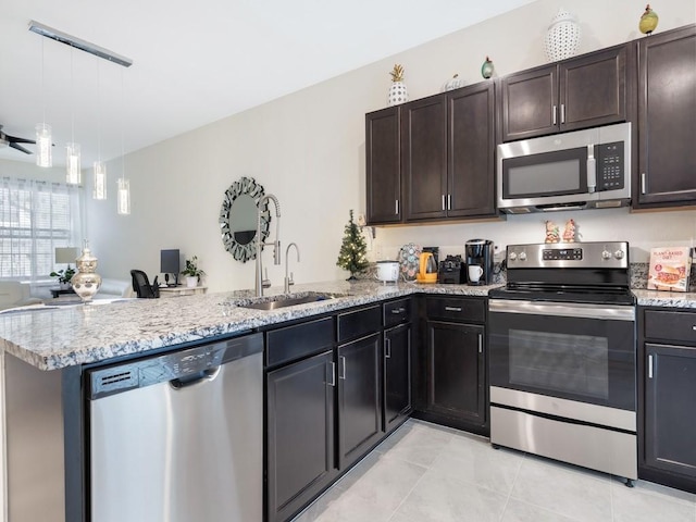 kitchen with stainless steel appliances, sink, decorative light fixtures, kitchen peninsula, and dark brown cabinetry