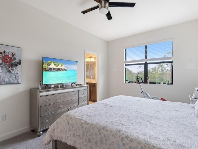 carpeted bedroom with ensuite bathroom and ceiling fan