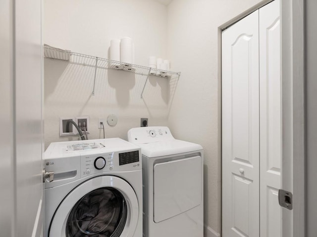 clothes washing area with washer and dryer