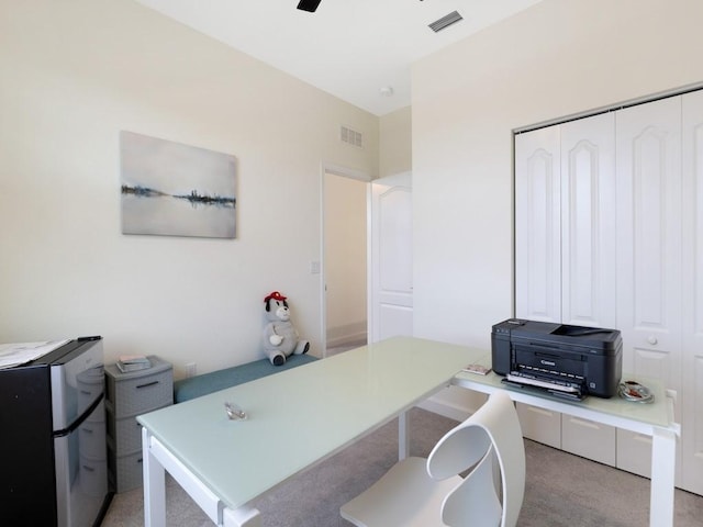 carpeted office space with ceiling fan