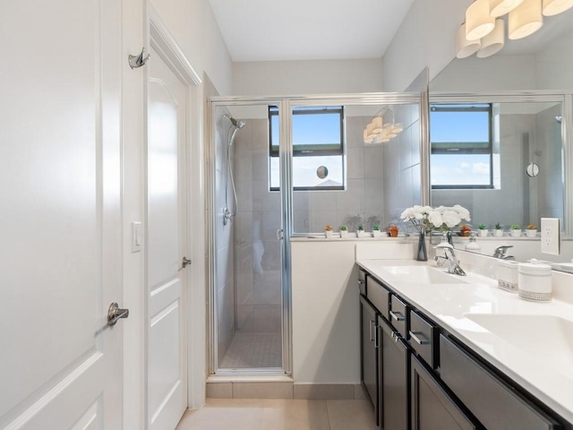 bathroom featuring walk in shower, vanity, tile patterned floors, and plenty of natural light