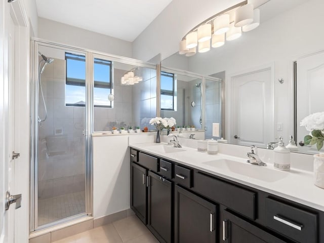 bathroom featuring tile patterned flooring, a shower with door, and vanity