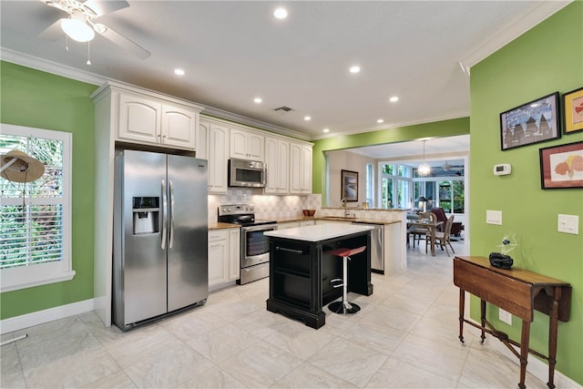 kitchen featuring a wealth of natural light, stainless steel appliances, kitchen peninsula, and a breakfast bar