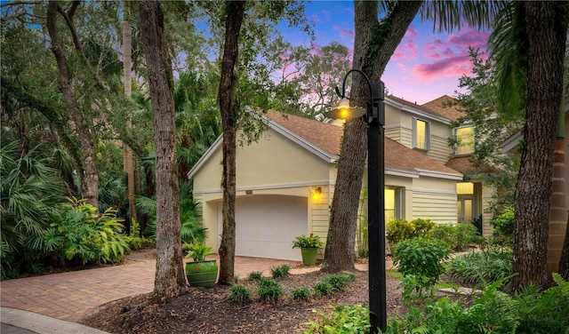 1619 Bent Oak Ln, Vero Beach, FL 32963 - obstructed view of property featuring a shingled roof, stucco siding, decorative driveway, and a garage