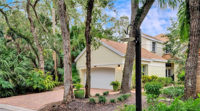 1619 Bent Oak Ln, Vero Beach, FL 32963 - view of front facade with a shingled roof, a garage, decorative driveway, and stucco siding