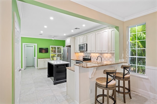 1619 Bent Oak Ln, Vero Beach, FL 32963 - kitchen featuring stainless steel appliances, ornamental molding, a center island, healthy amount of natural light, and recessed lighting