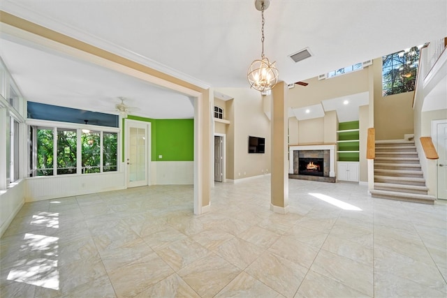 1619 Bent Oak Ln, Vero Beach, FL 32963 - unfurnished living room featuring ceiling fan, a lit fireplace, stairway, a chandelier, and baseboards