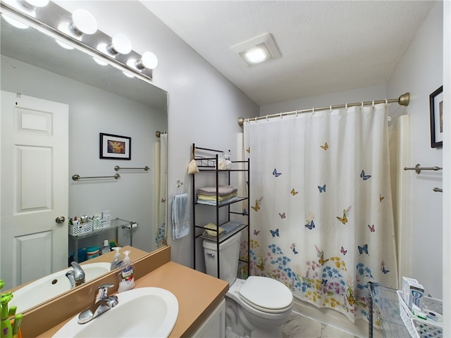 bathroom with tile patterned flooring, vanity, a textured ceiling, and toilet