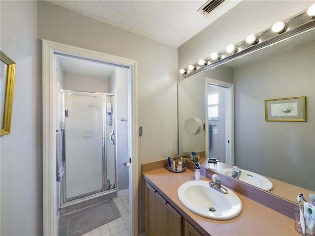 bathroom featuring a textured ceiling, vanity, and an enclosed shower