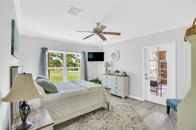 bedroom with ornamental molding, light wood-type flooring, visible vents, and baseboards