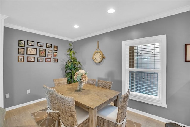 dining room featuring baseboards, crown molding, recessed lighting, and light wood-style floors