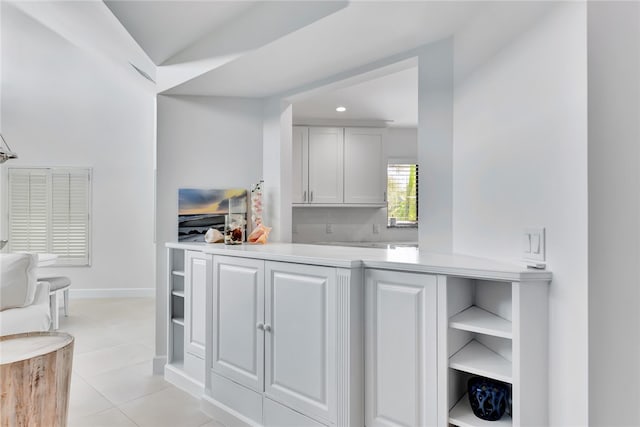 kitchen featuring white cabinetry, kitchen peninsula, and light tile patterned flooring