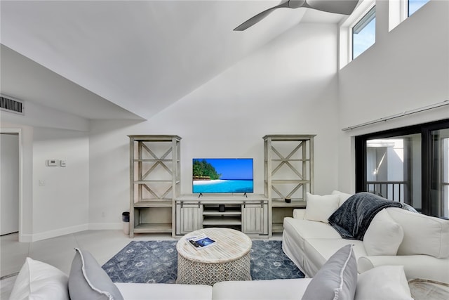 living room with ceiling fan and a towering ceiling