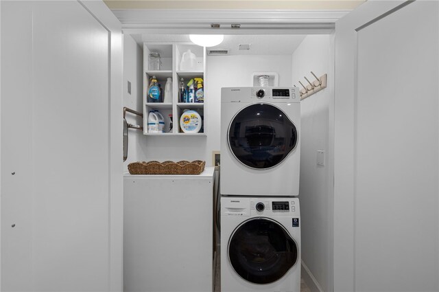 clothes washing area with stacked washer / dryer