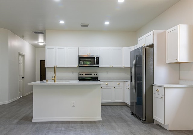 2565 86th Ave, Vero Beach, FL 32966 - kitchen with appliances with stainless steel finishes, light wood-style flooring, light countertops, white cabinets, and a center island with sink
