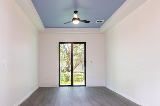 2565 86th Ave, Vero Beach, FL 32966 - empty room with dark wood-style flooring, ceiling fan, and a tray ceiling