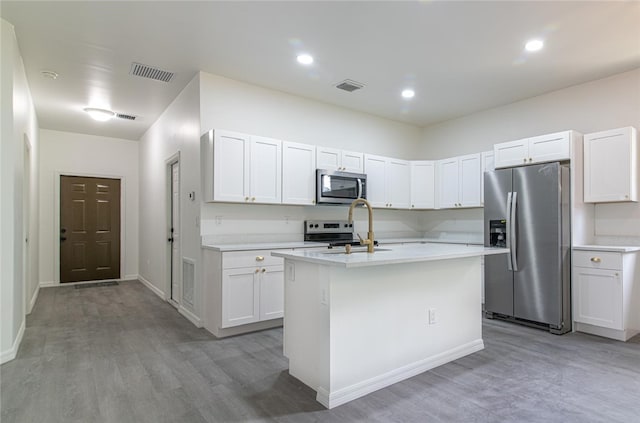 2565 86th Ave, Vero Beach, FL 32966 - kitchen featuring stainless steel appliances, light countertops, light wood finished floors, white cabinets, and recessed lighting
