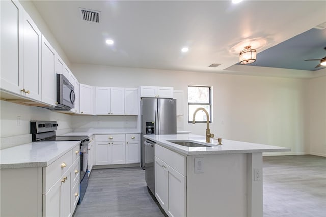 2565 86th Ave, Vero Beach, FL 32966 - kitchen with appliances with stainless steel finishes, a center island with sink, white cabinets, recessed lighting, and a ceiling fan