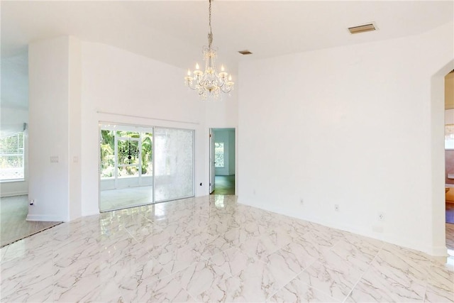spare room featuring marble finish floor, visible vents, a chandelier, and plenty of natural light