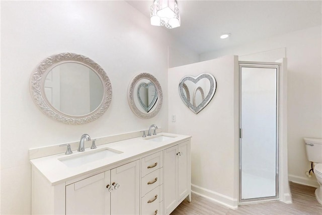 full bath featuring baseboards, wood finished floors, toilet, and a sink