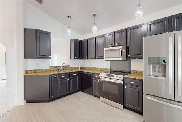 kitchen with lofted ceiling, a sink, stainless steel appliances, and arched walkways