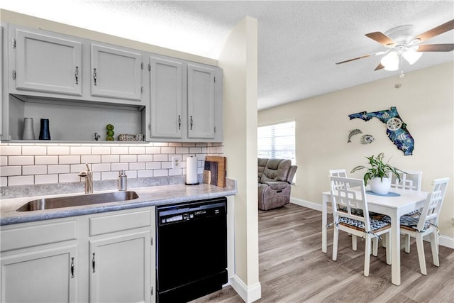 kitchen with black dishwasher, a sink, light wood-style flooring, open shelves, and a textured ceiling