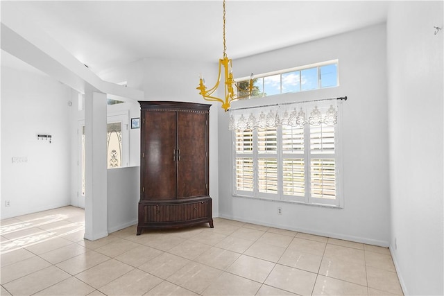 unfurnished room with a chandelier and light tile patterned floors