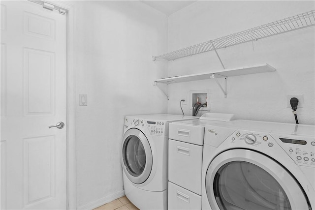 laundry area featuring light tile patterned floors and washing machine and clothes dryer