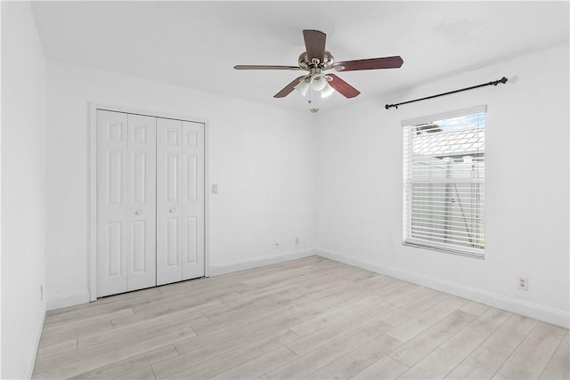 unfurnished bedroom featuring ceiling fan, a closet, and light hardwood / wood-style flooring