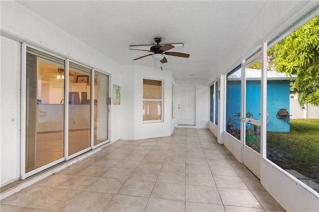 unfurnished sunroom featuring ceiling fan