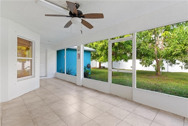 unfurnished sunroom featuring ceiling fan