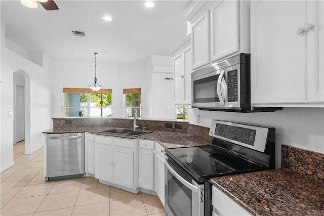 kitchen featuring appliances with stainless steel finishes, sink, pendant lighting, white cabinetry, and light tile patterned flooring