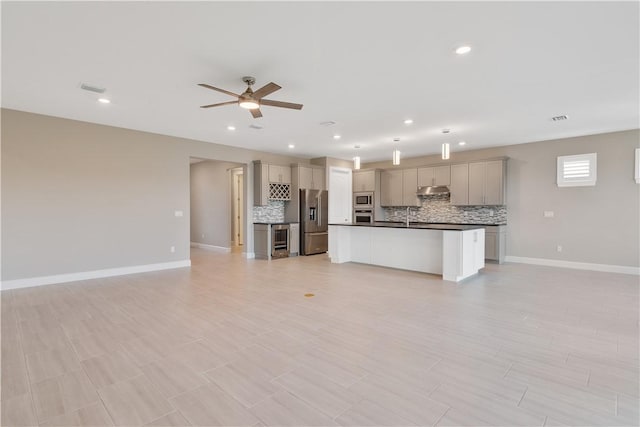 unfurnished living room featuring recessed lighting, visible vents, a ceiling fan, a sink, and baseboards