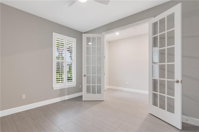 empty room featuring a ceiling fan, french doors, and baseboards