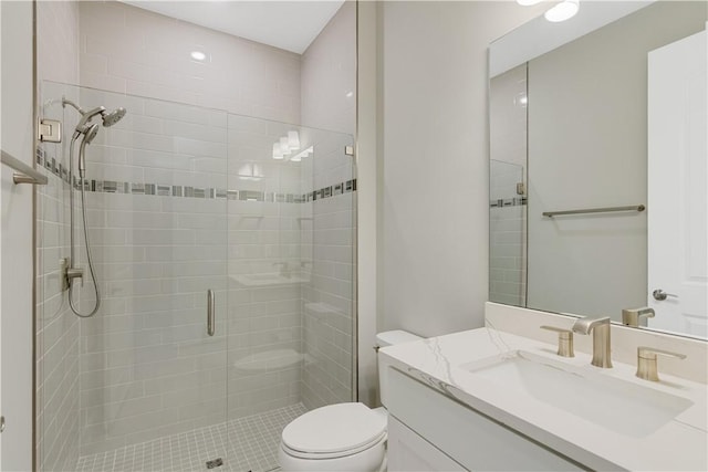 bathroom featuring a shower stall, vanity, and toilet