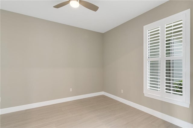 unfurnished room featuring light wood-type flooring, a ceiling fan, and baseboards